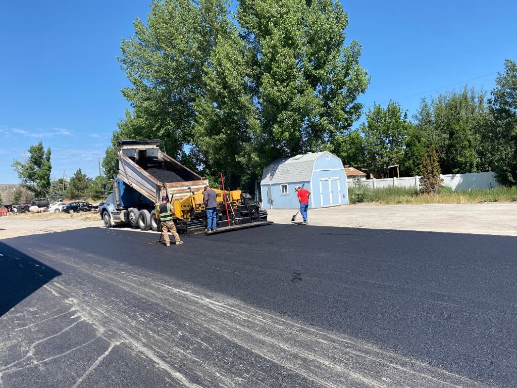 Newly paved asphalt driveway leading to a home